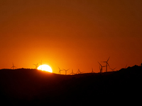 Wind energy is produced at sunset by the wind farm near Pietrapertosa in Basilicata on June 16, 2020. (