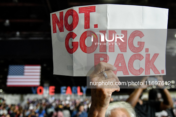 An attendee holds up a sign stating ''Not Going Back'' while awaiting former President Barack Obama to speak at a presidential campaign rall...