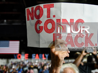 An attendee holds up a sign stating ''Not Going Back'' while awaiting former President Barack Obama to speak at a presidential campaign rall...