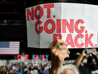 An attendee holds up a sign stating ''Not Going Back'' while awaiting former President Barack Obama to speak at a presidential campaign rall...