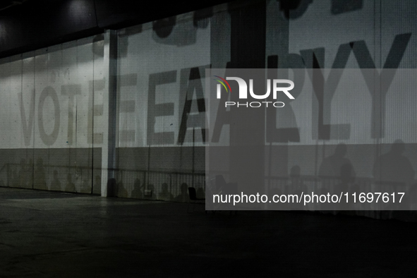 A shadow stating ''Vote Early'' is cast upon the back wall of The Huntington Place before former President Barack Obama speaks at a presiden...