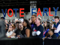 Attendees wait for former President Barack Obama to speak at a presidential campaign rally for Kamala Harris at The Huntington Place in Detr...