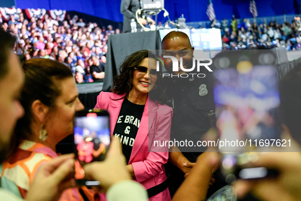 Michigan Governor Gretchen Whitmer pauses to take a photo with a Detroit Police officer during a presidential campaign rally for Kamala Harr...