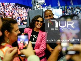 Michigan Governor Gretchen Whitmer pauses to take a photo with a Detroit Police officer during a presidential campaign rally for Kamala Harr...