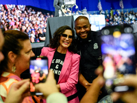 Michigan Governor Gretchen Whitmer pauses to take a photo with a Detroit Police officer during a presidential campaign rally for Kamala Harr...