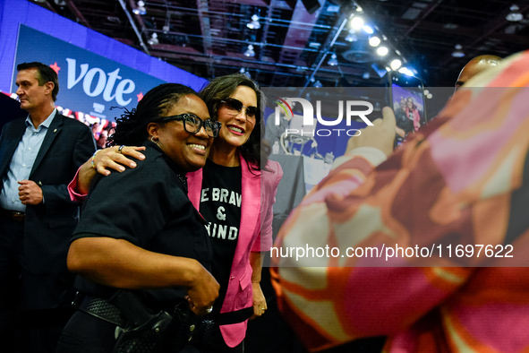 Michigan Governor Gretchen Whitmer pauses to take a photo with a Detroit Police officer during a presidential campaign rally for Kamala Harr...