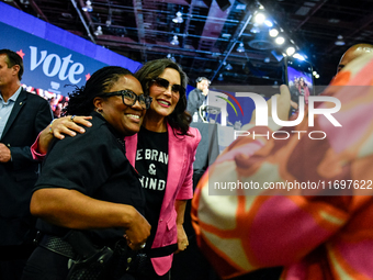 Michigan Governor Gretchen Whitmer pauses to take a photo with a Detroit Police officer during a presidential campaign rally for Kamala Harr...