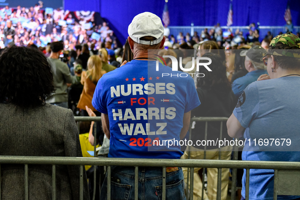 An attendee wears a ''Nurses for Harris-Walz'' shirt while listening to former President Barack Obama speak at a presidential campaign rally...