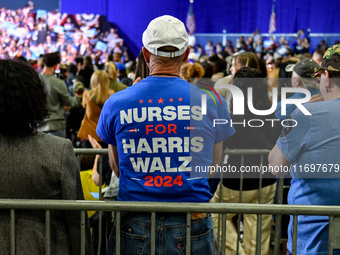 An attendee wears a ''Nurses for Harris-Walz'' shirt while listening to former President Barack Obama speak at a presidential campaign rally...