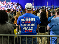 An attendee wears a ''Nurses for Harris-Walz'' shirt while listening to former President Barack Obama speak at a presidential campaign rally...