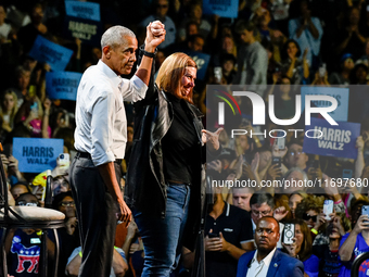 Former President Barack Obama raises the hand of U.S. Senate candidate Elissa Slotkin (D-MI) at a presidential campaign rally for Kamala Har...