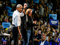 Former President Barack Obama raises the hand of U.S. Senate candidate Elissa Slotkin (D-MI) at a presidential campaign rally for Kamala Har...