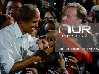 Former President Barack Obama shakes the hands of attendees at the conclusion of a presidential campaign rally for Kamala Harris at The Hunt...