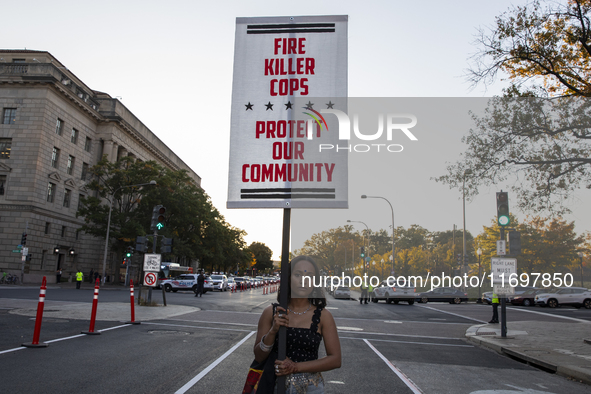 A person holds a sign during the National Day of Protest to Stop Police Brutality in Washington, D.C., United States, on October 22, 2024. P...