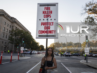 A person holds a sign during the National Day of Protest to Stop Police Brutality in Washington, D.C., United States, on October 22, 2024. P...