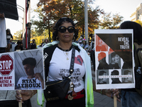 A person holds signs during the National Day of Protest to Stop Police Brutality in Washington, D.C., United States, on October 22, 2024. Pr...