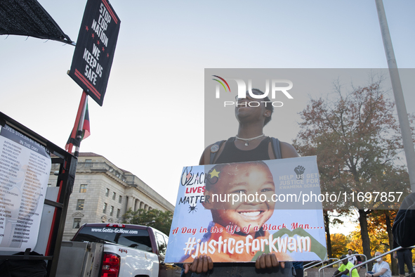 A person holds a sign during the National Day of Protest to Stop Police Brutality in Washington, D.C., United States, on October 22, 2024. P...