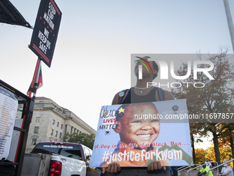 A person holds a sign during the National Day of Protest to Stop Police Brutality in Washington, D.C., United States, on October 22, 2024. P...