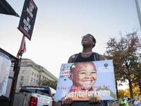 A person holds a sign during the National Day of Protest to Stop Police Brutality in Washington, D.C., United States, on October 22, 2024. P...