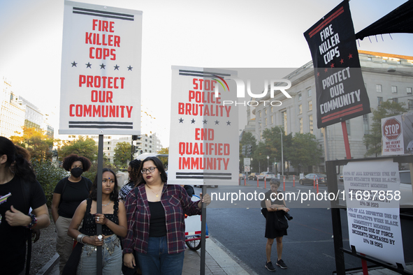 Protesters hold signs during the National Day of Protest to Stop Police Brutality in Washington, D.C., United States, on October 22, 2024. P...