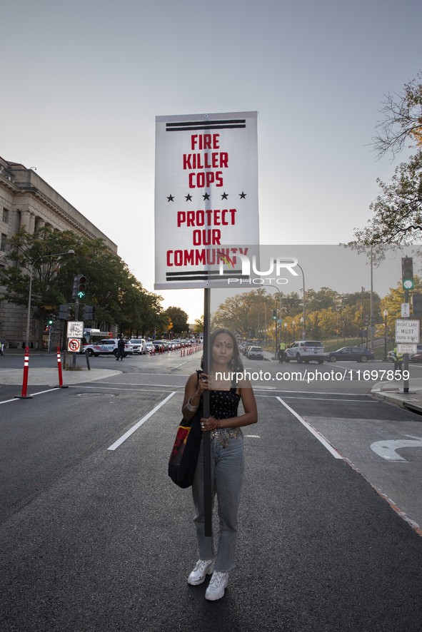 A person holds a sign during the National Day of Protest to Stop Police Brutality in Washington, D.C., United States, on October 22, 2024. P...