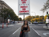 A person holds a sign during the National Day of Protest to Stop Police Brutality in Washington, D.C., United States, on October 22, 2024. P...