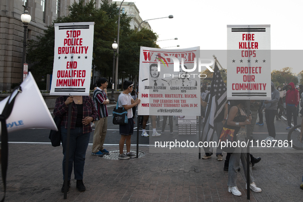 Protesters hold signs during the National Day of Protest to Stop Police Brutality in Washington, D.C., United States, on October 22, 2024. P...