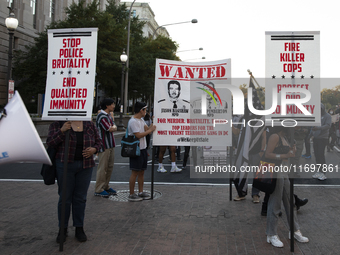 Protesters hold signs during the National Day of Protest to Stop Police Brutality in Washington, D.C., United States, on October 22, 2024. P...