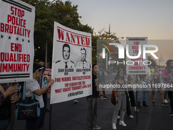 Protesters hold signs during the National Day of Protest to Stop Police Brutality in Washington, D.C., United States, on October 22, 2024. P...