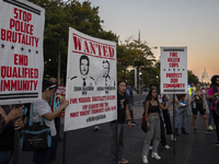 Protesters hold signs during the National Day of Protest to Stop Police Brutality in Washington, D.C., United States, on October 22, 2024. P...