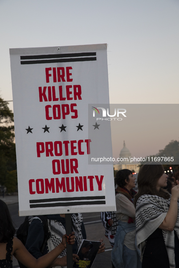 A person holds a sign during the National Day of Protest to Stop Police Brutality in Washington, D.C., United States, on October 22, 2024. P...