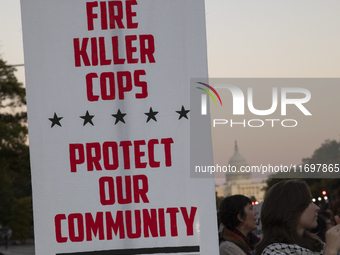 A person holds a sign during the National Day of Protest to Stop Police Brutality in Washington, D.C., United States, on October 22, 2024. P...