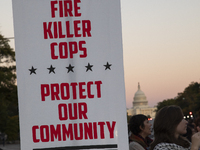 A person holds a sign during the National Day of Protest to Stop Police Brutality in Washington, D.C., United States, on October 22, 2024. P...