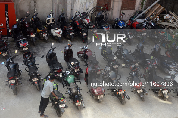 A parking lot employee arranges motorcycles at a parking place in Siliguri, India, on October 23, 2024. In India, environmental pollution is...