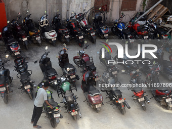 A parking lot employee arranges motorcycles at a parking place in Siliguri, India, on October 23, 2024. In India, environmental pollution is...