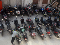 A parking lot employee arranges motorcycles at a parking place in Siliguri, India, on October 23, 2024. In India, environmental pollution is...