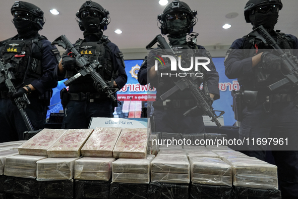 Thai Narcotics Suppression police officers stand guard next to 154 kilograms of heroin confiscated and hidden in their van to be smuggled fr...