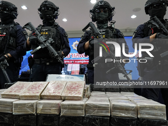 Thai Narcotics Suppression police officers stand guard next to 154 kilograms of heroin confiscated and hidden in their van to be smuggled fr...