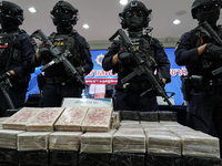 Thai Narcotics Suppression police officers stand guard next to 154 kilograms of heroin confiscated and hidden in their van to be smuggled fr...