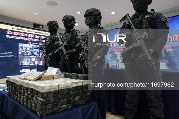 Thai Narcotics Suppression police officers stand guard next to 154 kilograms of heroin confiscated and hidden in their van to be smuggled fr...