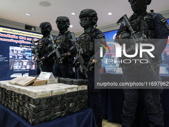 Thai Narcotics Suppression police officers stand guard next to 154 kilograms of heroin confiscated and hidden in their van to be smuggled fr...