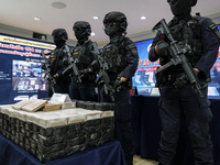 Thai Narcotics Suppression police officers stand guard next to 154 kilograms of heroin confiscated and hidden in their van to be smuggled fr...