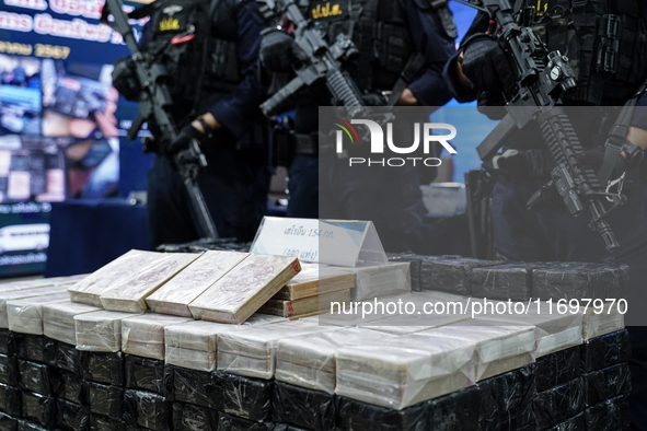 Thai Narcotics Suppression police officers stand guard next to 154 kilograms of heroin confiscated and hidden in their van to be smuggled fr...