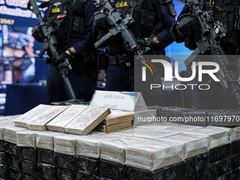 Thai Narcotics Suppression police officers stand guard next to 154 kilograms of heroin confiscated and hidden in their van to be smuggled fr...