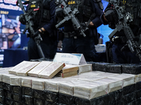 Thai Narcotics Suppression police officers stand guard next to 154 kilograms of heroin confiscated and hidden in their van to be smuggled fr...