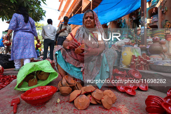 A woman vendor colors earthen lamps 'Diyas' at her roadside shop ahead of the Diwali Festival in Jaipur, Rajasthan, India, on October 23, 20...