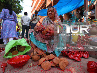 A woman vendor colors earthen lamps 'Diyas' at her roadside shop ahead of the Diwali Festival in Jaipur, Rajasthan, India, on October 23, 20...