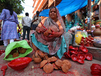 A woman vendor colors earthen lamps 'Diyas' at her roadside shop ahead of the Diwali Festival in Jaipur, Rajasthan, India, on October 23, 20...