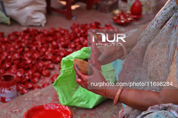 A woman vendor colors earthen lamps 'Diyas' at her roadside shop ahead of the Diwali Festival in Jaipur, Rajasthan, India, on October 23, 20...