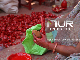 A woman vendor colors earthen lamps 'Diyas' at her roadside shop ahead of the Diwali Festival in Jaipur, Rajasthan, India, on October 23, 20...